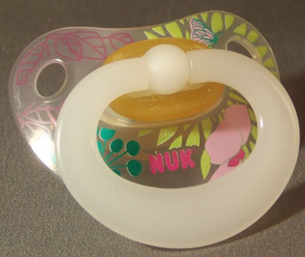 Translucent NUK Pacifier with floral pattern.